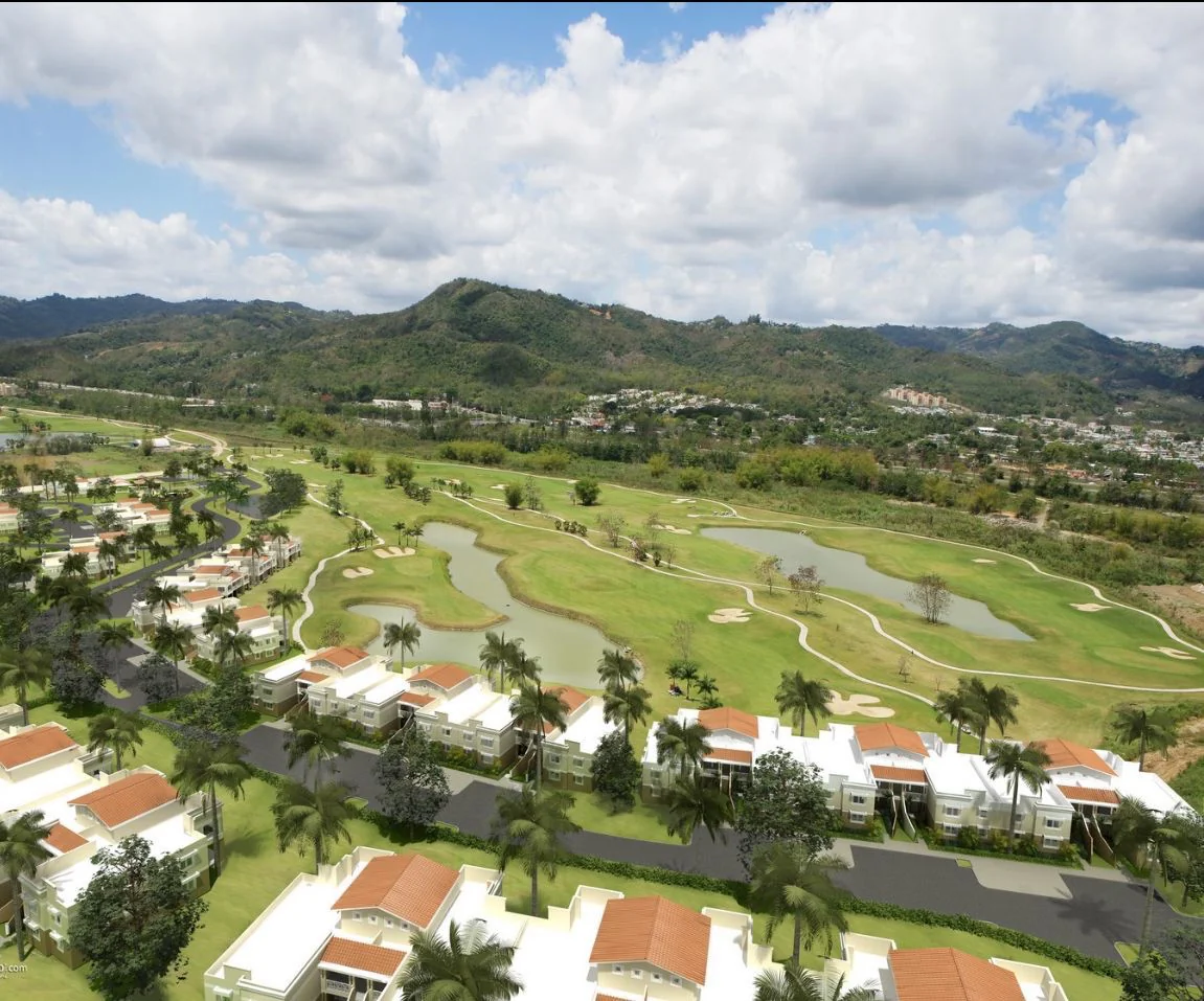 Vista aérea del área verde y campo de golf del entorno de Caguas Real con montañas al fondo